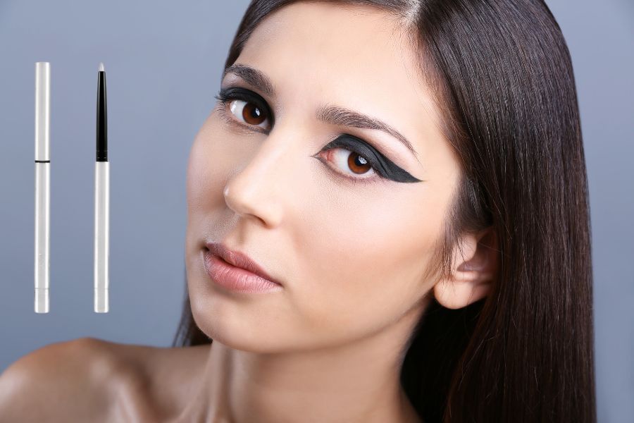 Người mẫu với đường kẻ mắt đậm, bên cạnh là hai bút kẻ mắt trên nền màu xám.