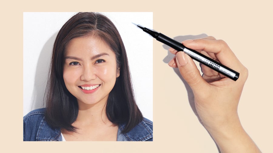Người đang cười, tóc ngắn. Tay cầm bút kẻ mắt màu đen, nền màu be.
