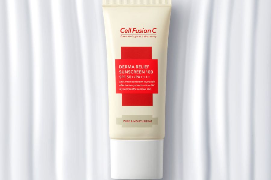 Kem chống nắng trong tuýp màu trắng, nhãn đỏ, có chỉ số SPF 50+/PA++++, trên nền vải trắng.