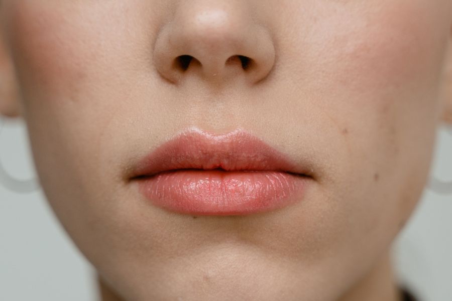Cận cảnh đôi môi với son hồng nhẹ, ánh sáng dịu nhẹ, không xác định danh tính.