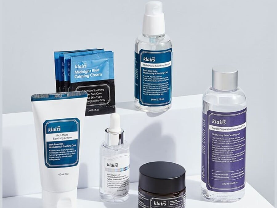 Các sản phẩm chăm sóc da được sắp xếp trên bề mặt trắng, gồm kem, serum và nước hoa hồng.