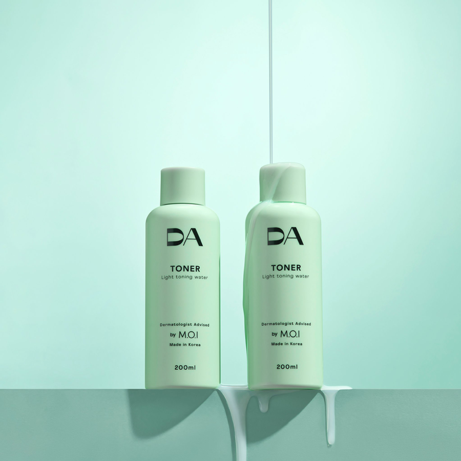 Hai chai toner màu xanh nhạt trên nền cùng màu, với một dòng chất lỏng chảy xuống chai bên phải.